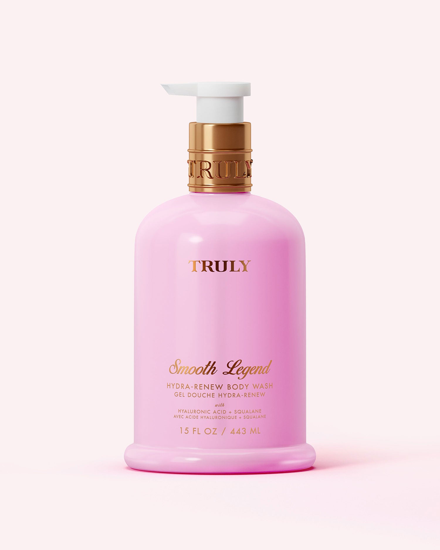 A pink bottle of Truly Beauty Hydra-Renew Body Wash, 15 fl oz (443 mL), with a gold and white pump, gold lettering, sits against a light pink background.