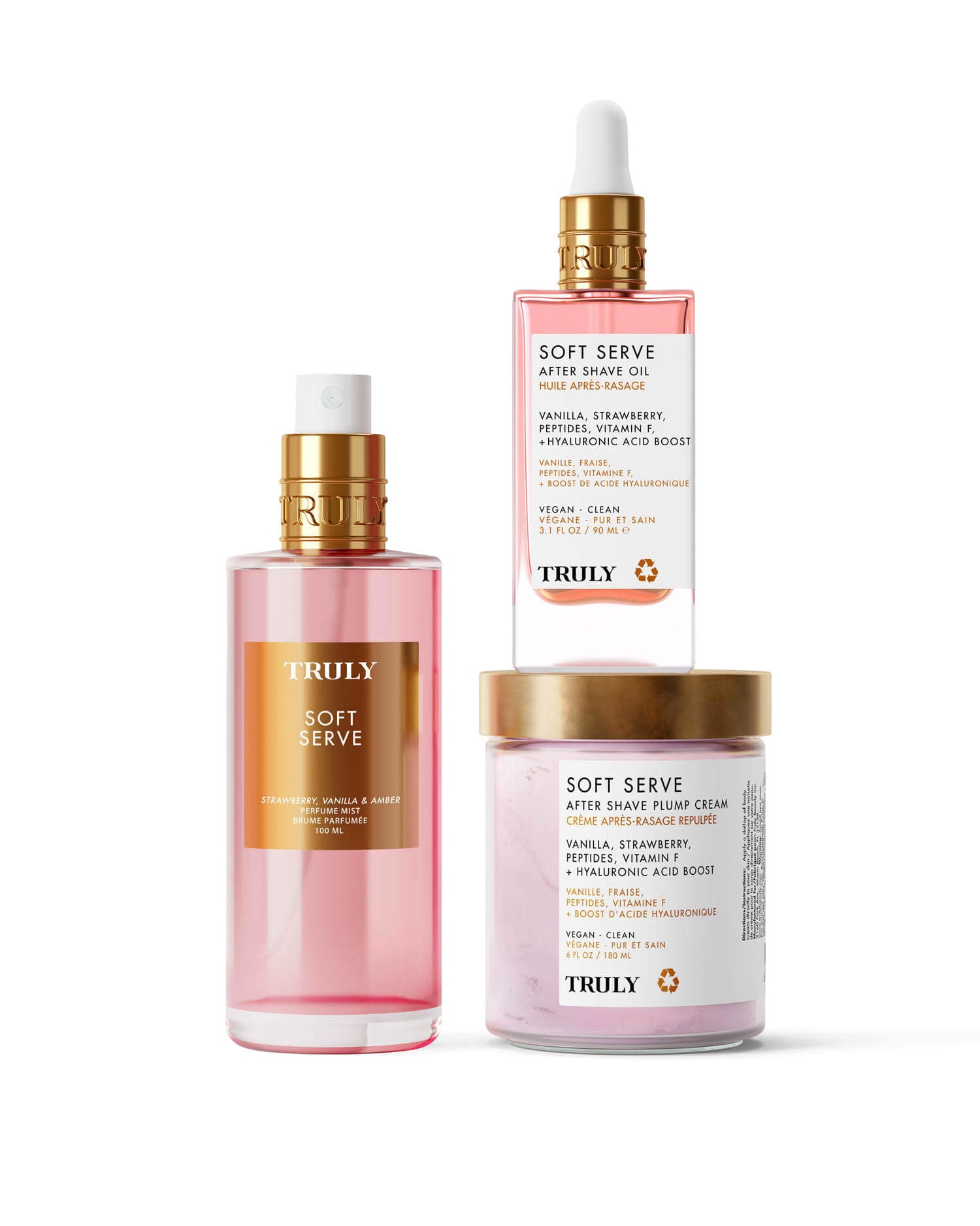 Three pink products from Truly Beauty’s Soft Serve Luxury Trio—spray bottle, dropper bottle, and “Soft Serve” jar—are displayed against a light background, offering strawberry-scented hydration with peptides and strawberry extract.