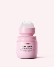 A light pink container of Truly Beauty Soft Serve Serum Deodorant with a rounded applicator and gold lettering sits against a pale pink background—this serum deodorant gently cares for your underarms.