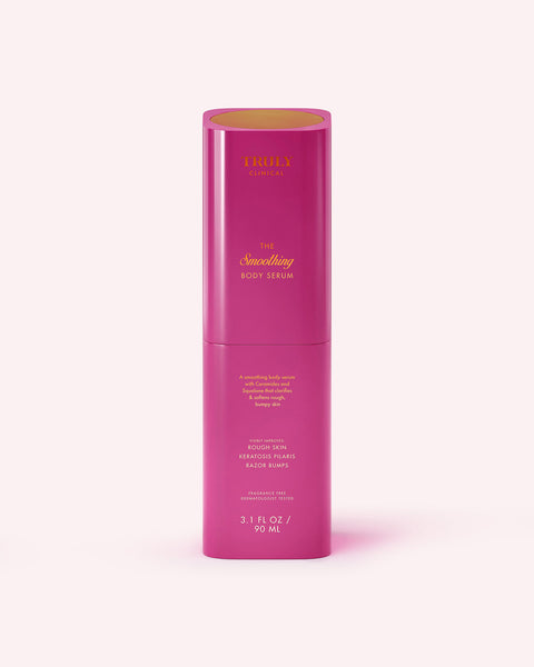A tall, cylindrical pink bottle labeled “The Smoothing Body Serum” by Truly Beauty targets rough, bumpy skin and keratosis pilaris. It holds 3.1 fl oz (90 ml) and features gold and white text, standing upright on a light pink background.