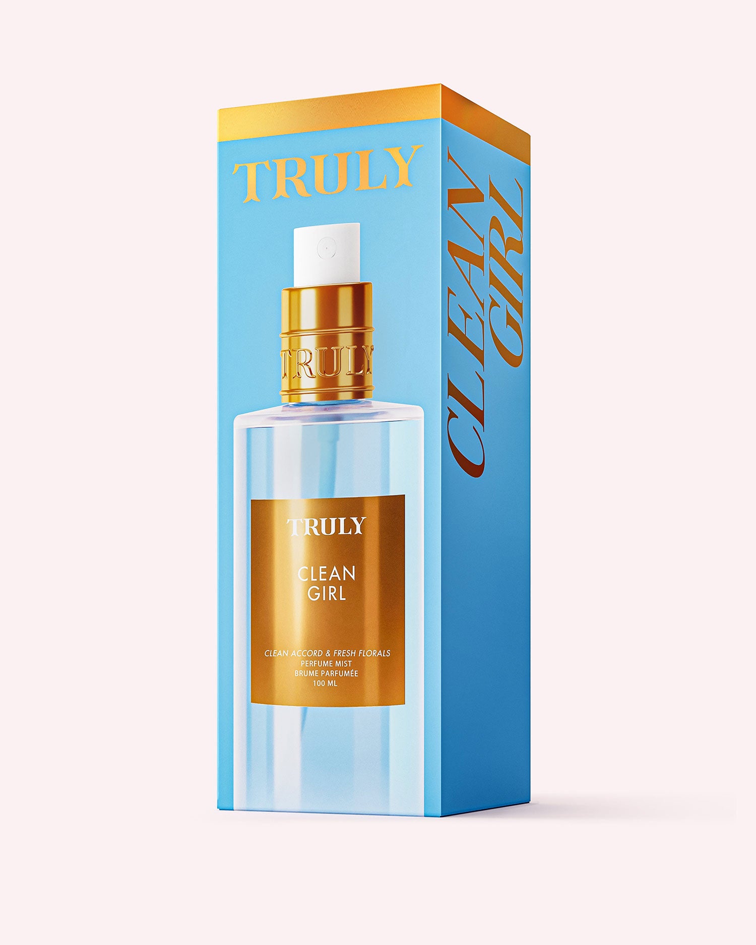 A blue and gold box labeled Clean Girl Perfume Mist by Truly Beauty showcases a clear, gold-capped bottle, capturing the fresh, clean fragrance of florals against a light pink background.