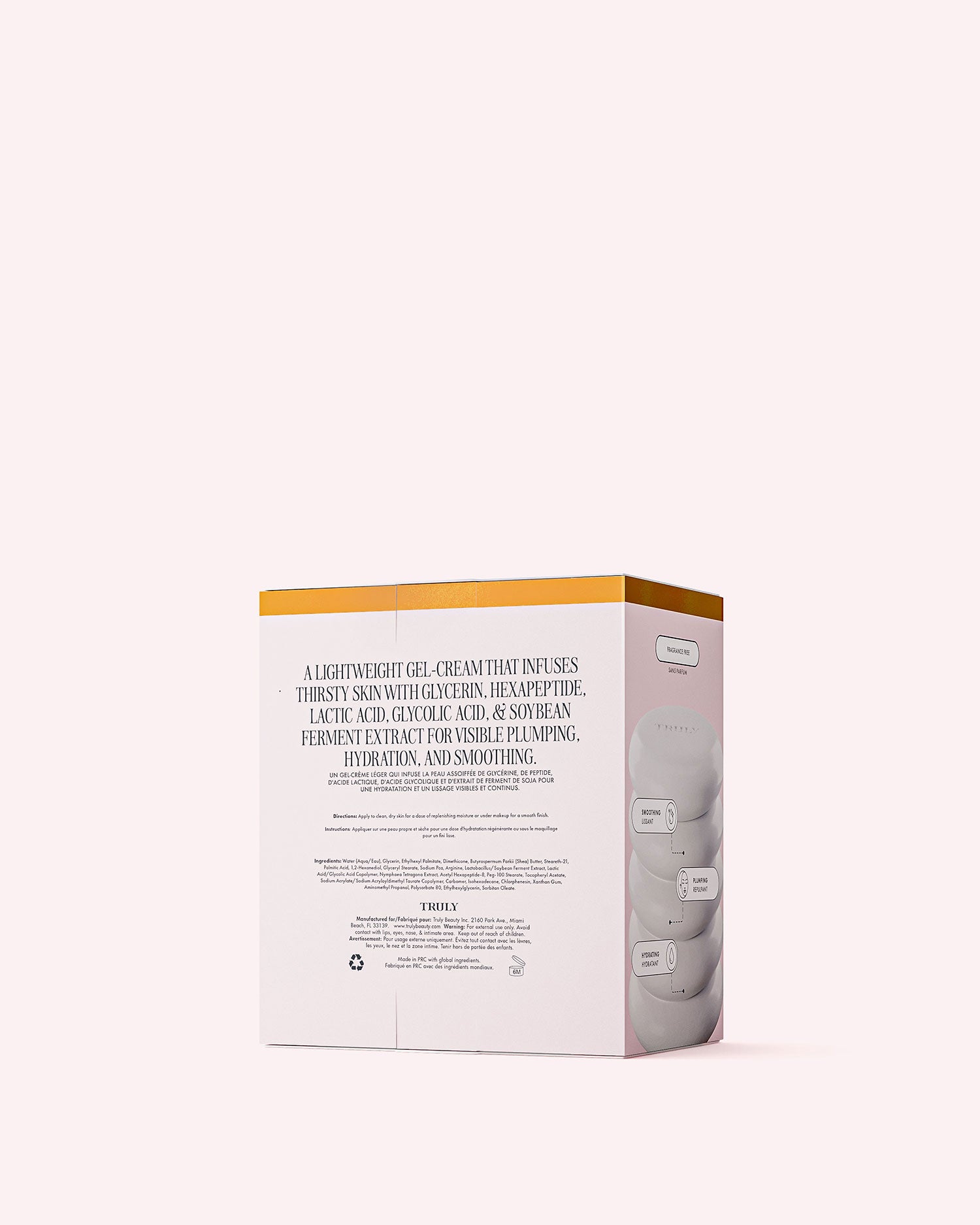 A pale pink and white box of Truly Beauty’s Cloud Cream Pro-Peptide Facial Moisturizer, topped with a gold stripe and featuring product details, stands against a plain pale pink background.