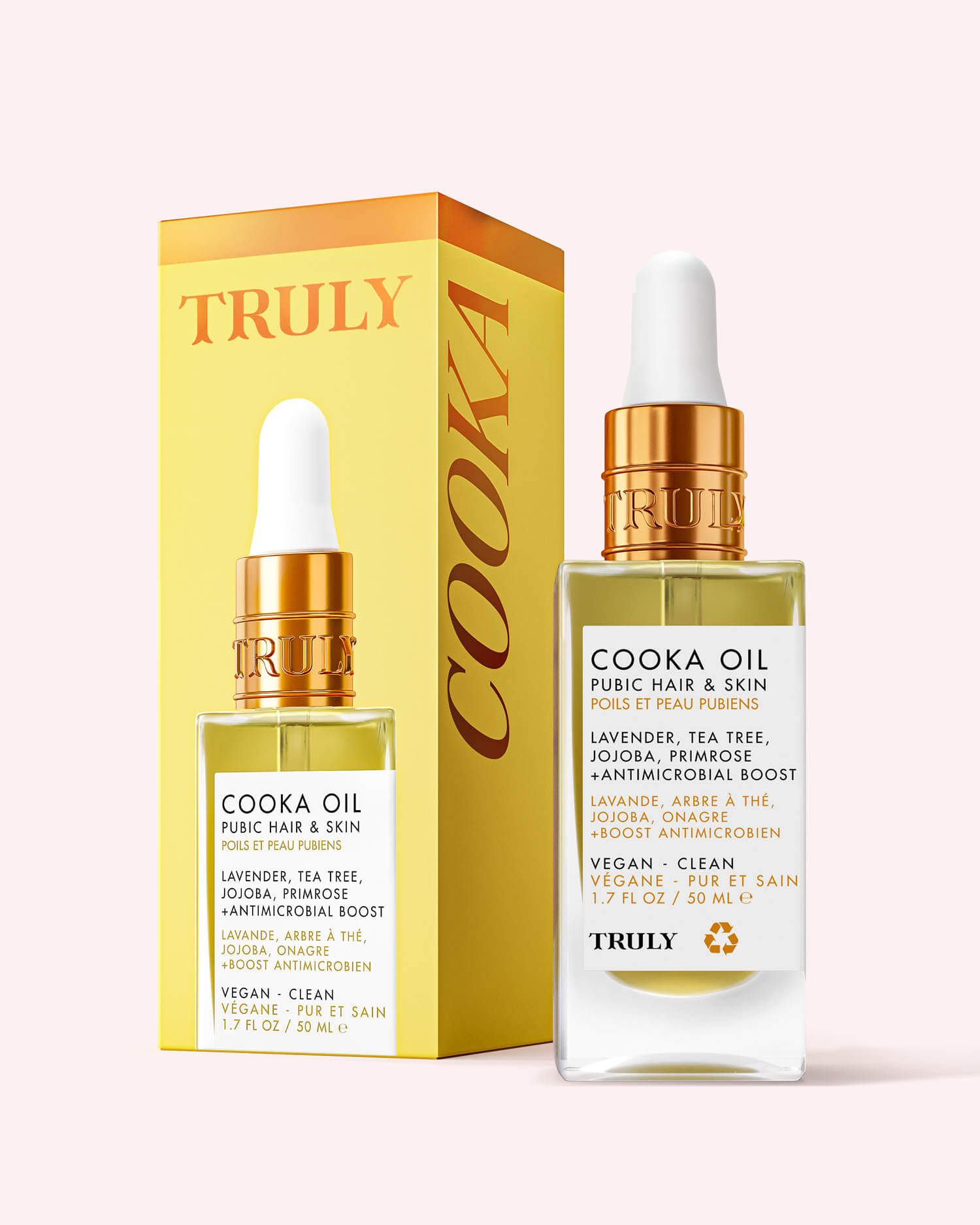 A bottle of Truly Beauty Cooka Oil with a dropper cap sits by its yellow-orange box. The label notes use for pubic hair, key ingredients lavender and argan oils, and that it’s vegan, clean, and soothes ingrown hairs.