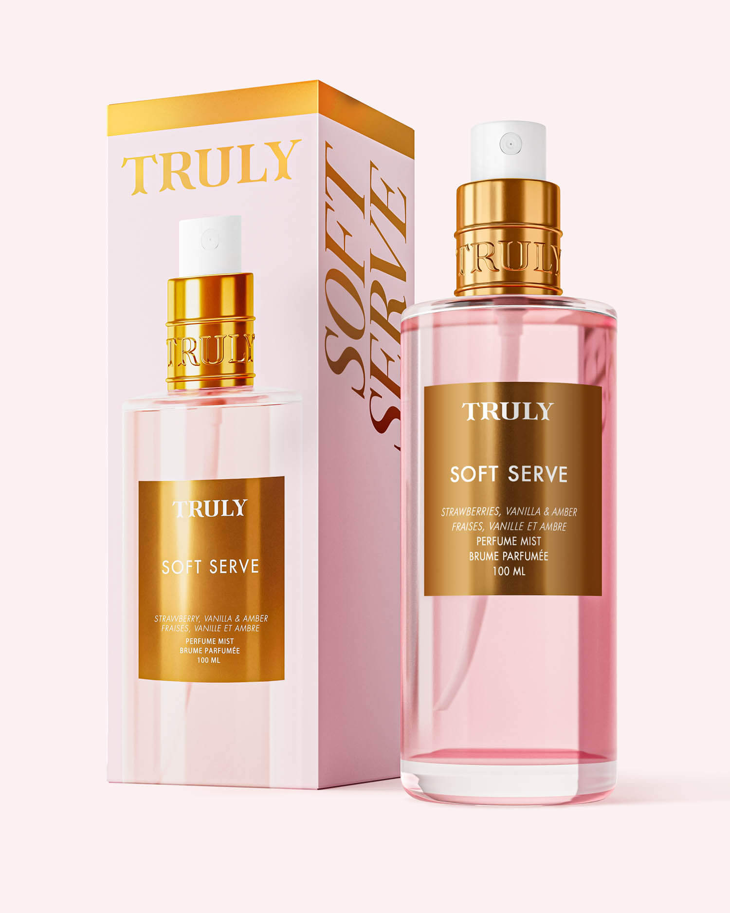 A pink bottle of Truly Beauty Soft Serve Perfume Mist with a gold cap sits beside its matching box, both adorned with gold lettering and soft pink accents, showcasing its strawberries and cream scent.