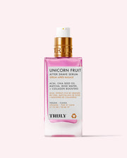 A pink and white 3.1 fl oz bottle of Truly Beauty Unicorn Fruit After Shave Serum with a gold pump, featuring vegan, clean ingredients like acai and chia seed oil to soothe post-shave redness and prevent ingrowns.
