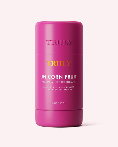 A pink stick of Truly Beauty Unicorn Fruit Skin Brightening and Smoothing Deodorant with mandelic acid and niacinamide, designed to smooth, brighten, and reduce underarm discoloration, shown against a light background.