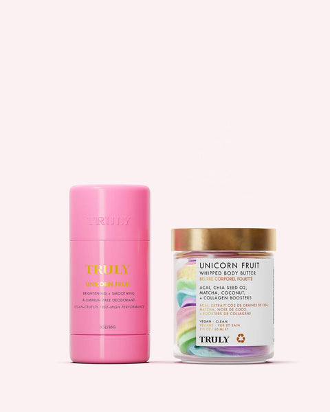 The Truly Beauty Unicorn Fruit Duo includes a pink cylindrical brightening deodorant with a cotton candy scent and a jar of pastel whipped body butter made with natural ingredients, both displayed on a pale pink background.