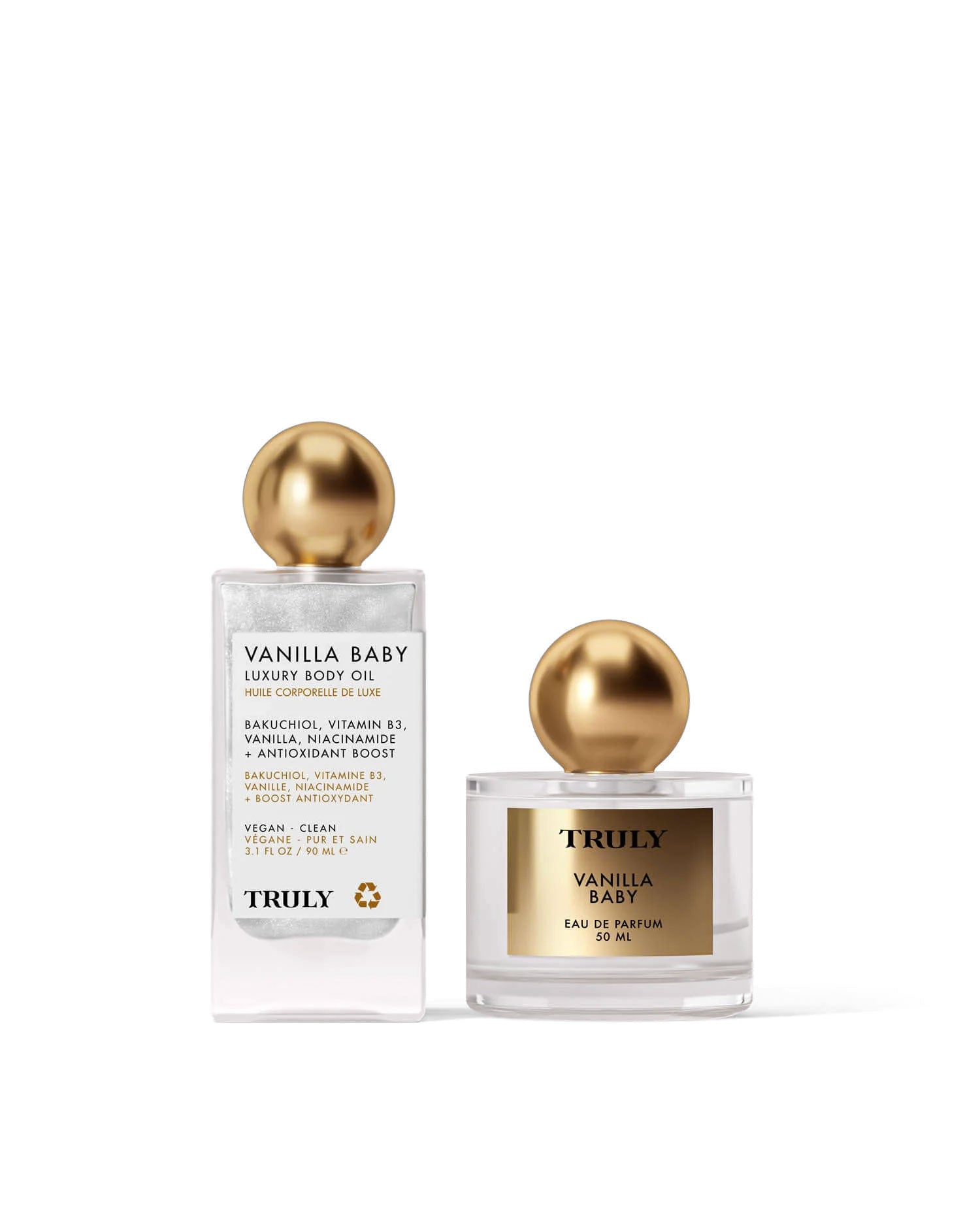 The Vanilla Baby Fragrance Duo by Truly Beauty—luxury body oil and eau de parfum, both with gold spherical caps—is beautifully displayed on a pale pink background.