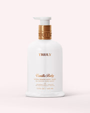 A white 15 fl oz bottle of Truly Beauty Hydra-Renew Body Wash with a gold pump and label sits on a pale pink background. This sulfate-free wash gently cleanses and nourishes delicate skin.
