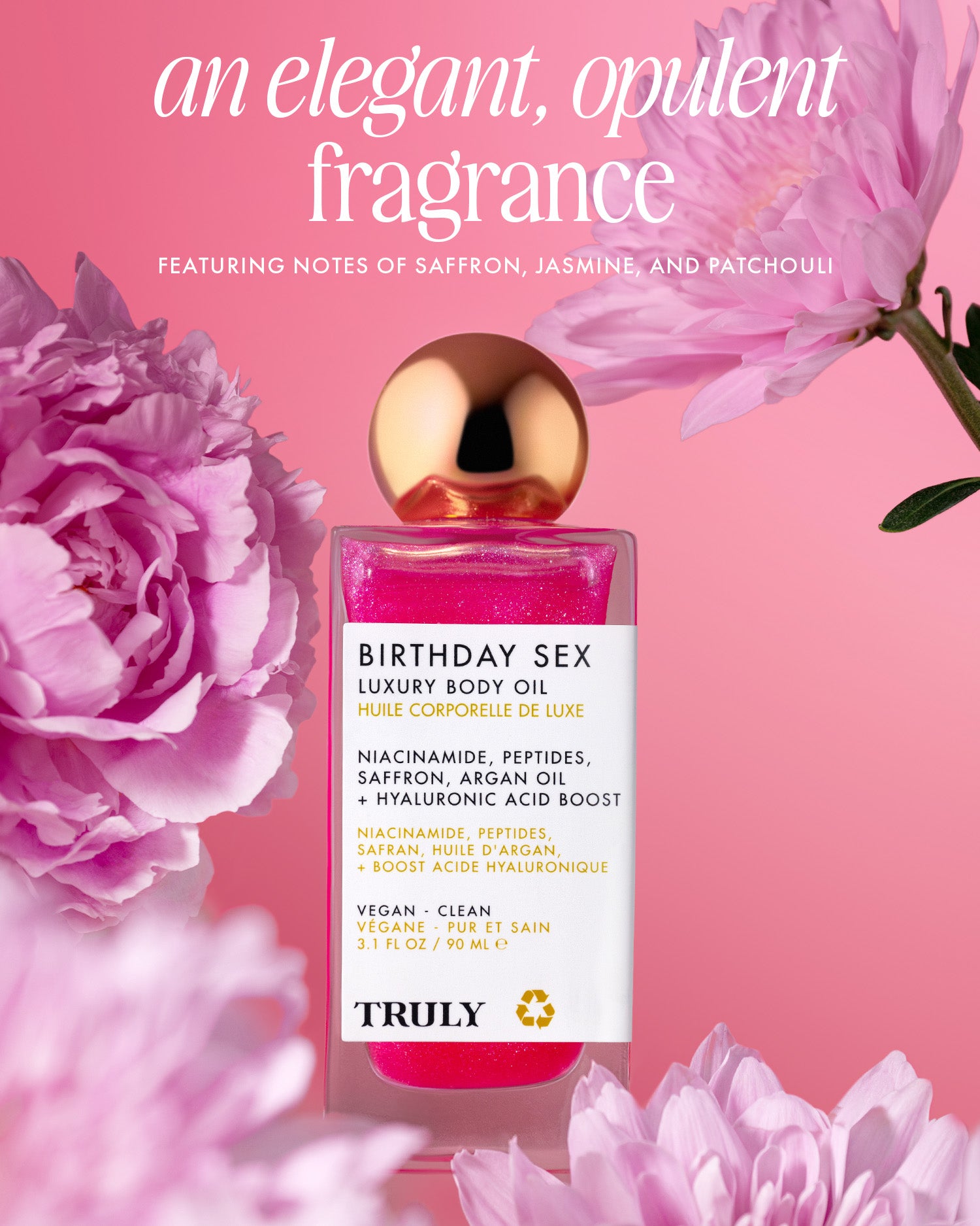 A pink bottle of Truly Beauty’s Birthday Sex Luxury Body Oil with a gold cap sits among pink flowers. The text highlights its rich scent—saffron, jasmine, patchouli—and the peptide-infused formula for luminous skin.
