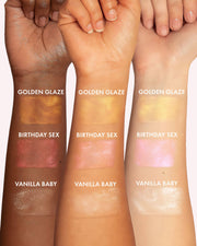 Three forearms of varying skin tones show swatches of Truly Beauty’s Birthday Sex Luxury Body Oil—infused with illuminating shimmer and peptides to enhance and nourish skin for all tones.