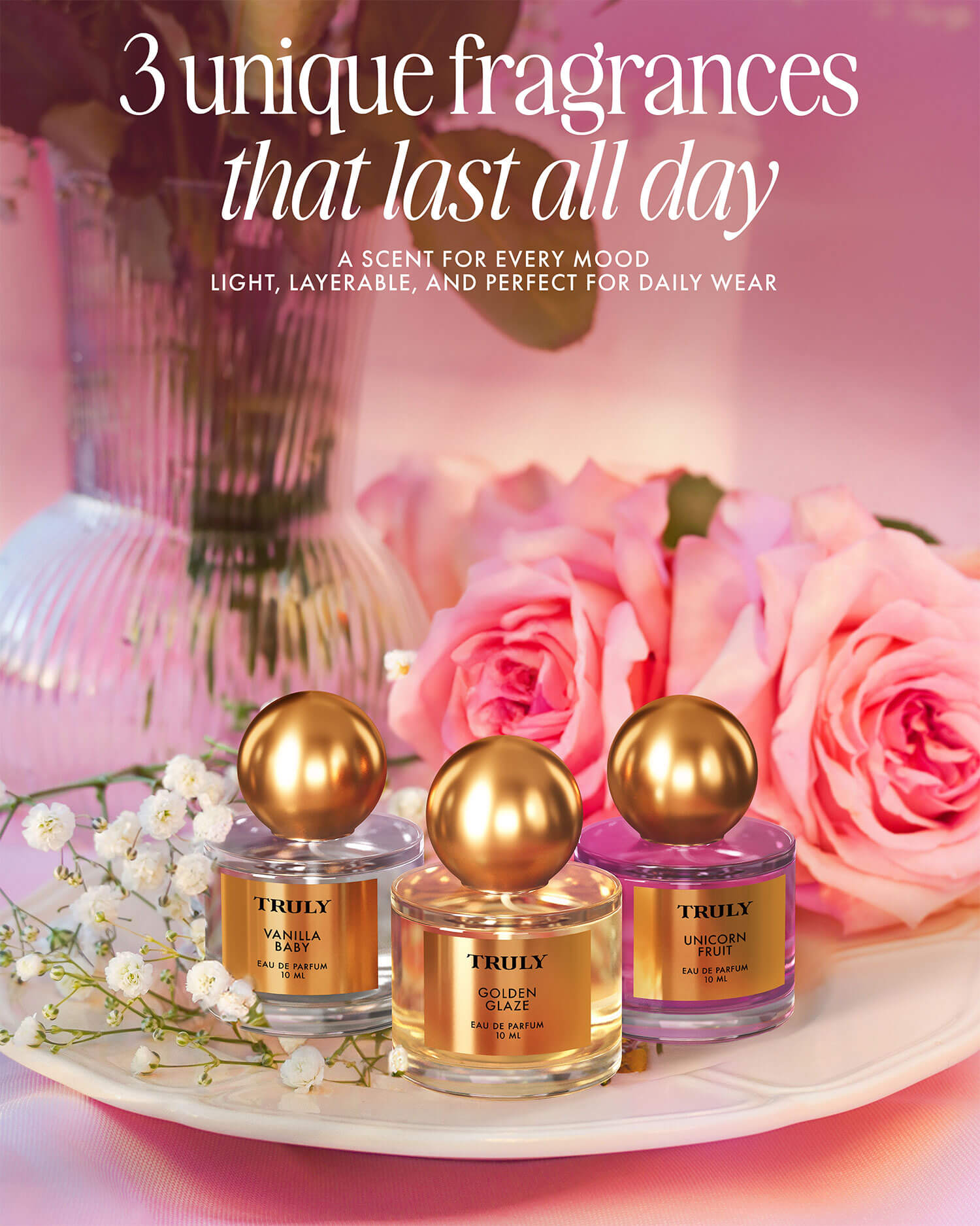 Three bottles of Truly Beauty’s The Perfumer’s Set, each topped with a gold cap, are displayed among pink roses and babys breath. Discover 3 unique fragrances designed to be your all-day signature scent.