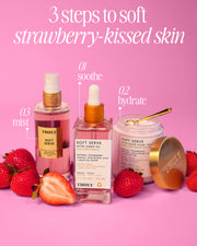 The Truly Beauty Soft Serve Luxury Trio is arranged with fresh strawberries on a pink background. Text reads, “3 steps to soft strawberry-kissed skin: soothe, hydrate, mist.”.