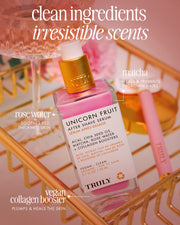 A pink bottle of Truly Beauty Unicorn Fruit After Shave Serum sits on a gold tray with a rose and beauty items, showcasing its clean ingredients, ingrown-fighting power, calming post-shave redness, plus rose water and vegan collagen benefits.