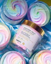 Three open jars and one closed jar of pastel rainbow-swirled body butter sit on blue. The labeled jar reads “Unicorn Fruit Whipped Body Butter” by Truly Beauty. Text highlights its moisturizing, natural ingredients, and vibrant swirled look.