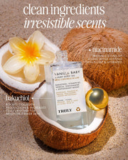 A bottle of Truly Beauty Vanilla Baby Luxury Body Oil sits on a halved coconut, with a plumeria and golden sphere nearby. Text highlights clean ingredients, irresistible scents, and anti-aging, plumping benefits from niacinamide and bakuchiol.