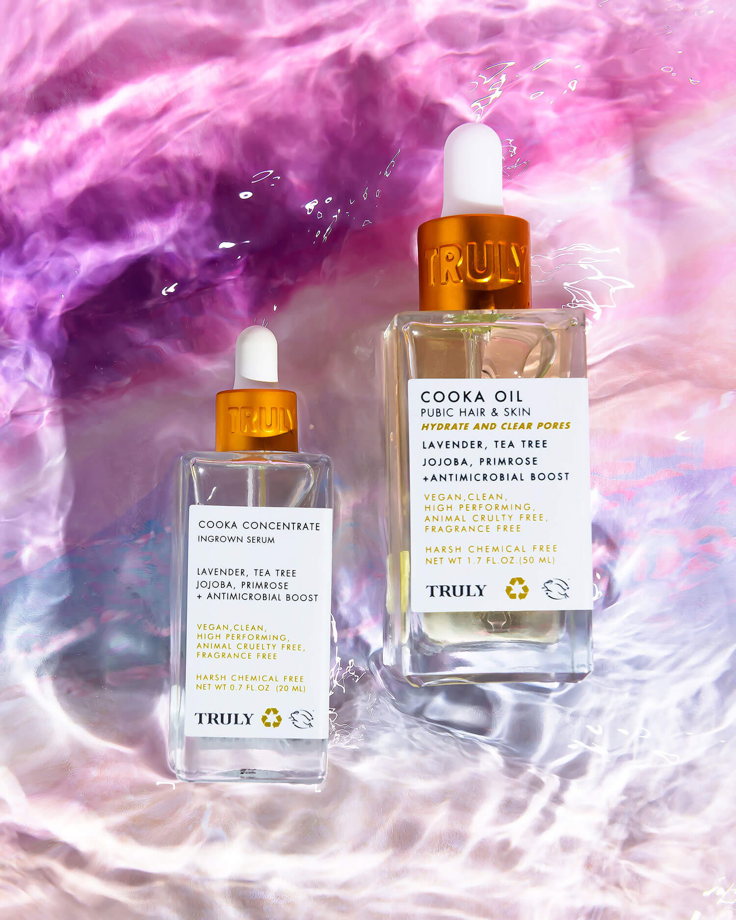 The Cooka Set by Truly Beauty, featuring two bottles with amber droppers—Cooka Concentrate and Cooka Oil—stands on a pink-purple surface. Formulated with lavender and jojoba, they soothe the bikini line after shaving with a double bladed razor.