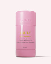 A pink cylindrical stick of Truly Beauty’s Unicorn Fruit Skin Brightening and Smoothing Deodorant stands upright on a light background. Its gold and white packaging highlights this aluminum-free must-have for your underarm care routine.